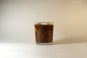 Ice coffee with milk in a glass, ice cubes.