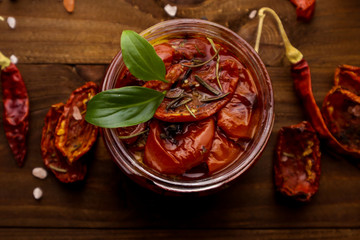 Glass jar with sun dried tomatoes on wooden table
