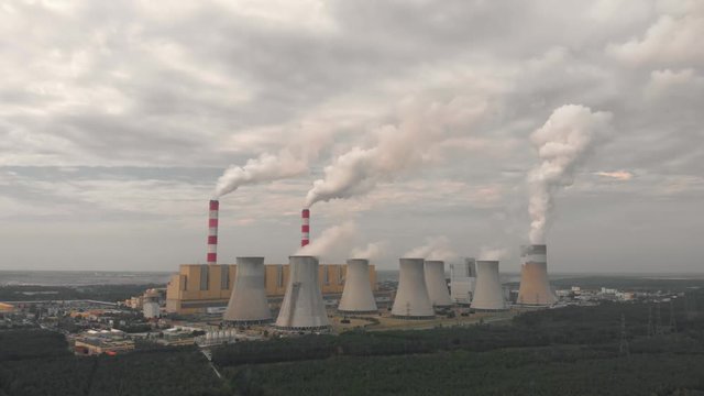 Aerial view of Belchatow coal power plant. Biggest fossil fuel emission producer in Europe increasing climate change. Smoke rising from chimneys and water vapor from cooling towers. Poland