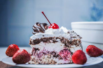 Slice of cake with cherries and strawberries