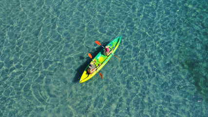 Aerial drone photo of 2 women canoeing in tropical Caribbean turquoise sea