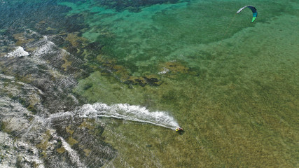 Aerial drone photo of kite surfer practising acrobatics in tropical exotic open ocean bay with emerald sea on a windy day
