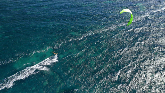 Aerial drone photo of kite surfer practising acrobatics in tropical exotic open ocean bay with emerald sea on a windy day