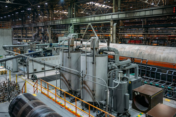 Steel tanks connected by pipelines in factory workshop 