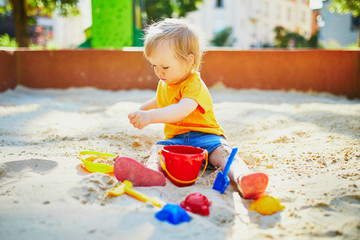 little girl having fun on playground in sandpit