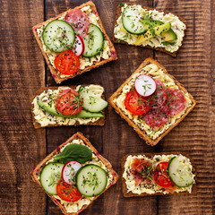 Sandwiches with cream cheese, vegetables and salami.