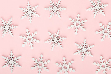Christmas background. White snow decorations on a pink background.
