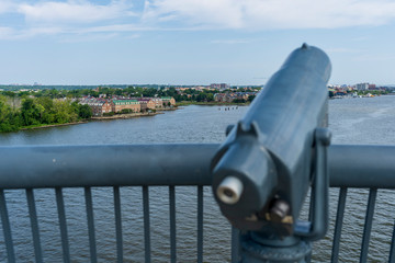 A telescope is mounted on a scenic vista along the Woodrow Wilson Bridge, overlooking the cities of...