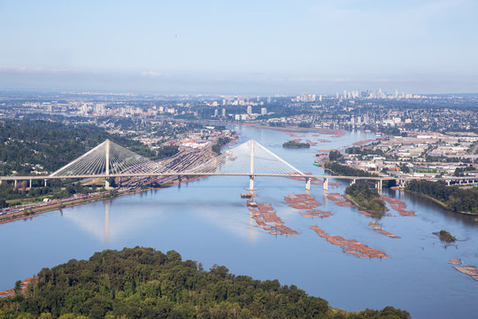 Aerial view of Fraser River and Port Mann Bridge during a vibrant summer morning. Taken in Greater Vancouver, British Columbia, Canada.