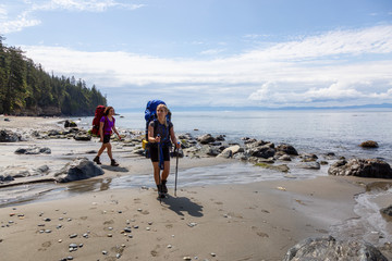 Adventurous friends are hiking Juan de Fuca Trail to Mystic Beach on the Pacific Ocean Coast during a sunny summer day. Taken near Port Renfrew, Vancouver Island, BC, Canada.