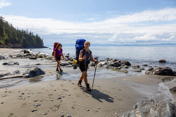 Adventurous friends are hiking Juan de Fuca Trail to Mystic Beach on the Pacific Ocean Coast during...