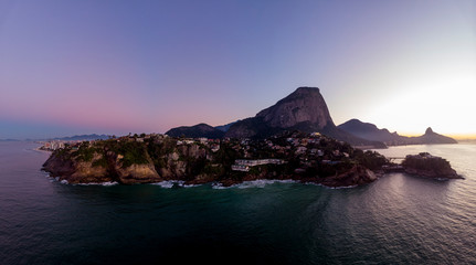 Panoramic view of the coastline and beach of Joatinga in Rio de Janeiro with its beautiful picturesque natural richness and far in the background the well known landmark peaks of the city