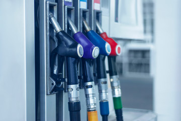 Gas station close-up with colored fuel hoses.