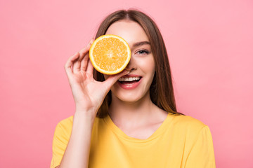 front view of smiling attractive girl holding cut orange isolated on pink