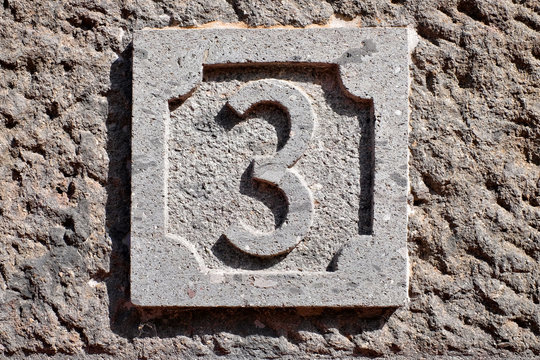 3, number three, decorative numeral on gray stone surface.