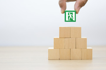 Fire exit icon on wooden block in  pyramid shape.