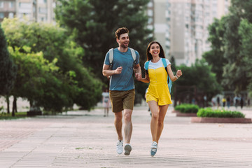 handsome man and asian woman running and looking away