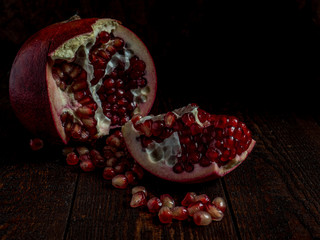 Fresh pomegranate with grains on black background.