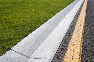 close up of border on road near green and fresh grass