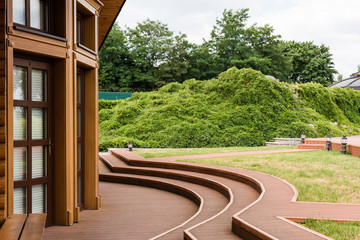 luxurious house near green trees and grass in summertime
