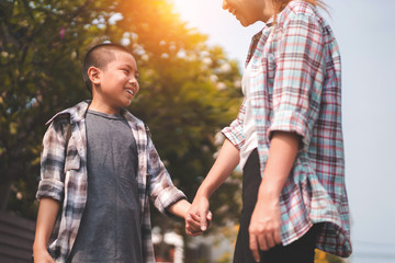 Mother or parent holding hand son or pupil with backpack go to school, Back to school concept,...