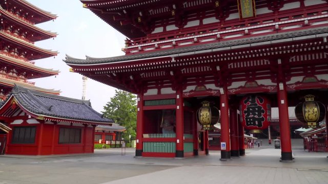 Amazing view of Asakusa temple in Tokyo with traditional red architecture and huge lanterns hanging under the buildings. Popular tourist destination of Japan.