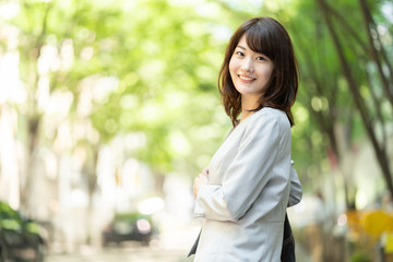 portrait of asian businesswoman walking in sidewalk