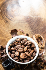 cup with coffee beans and rustic wooden background