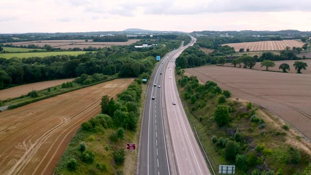 Aerial View over Motorway Across Countryside Fields