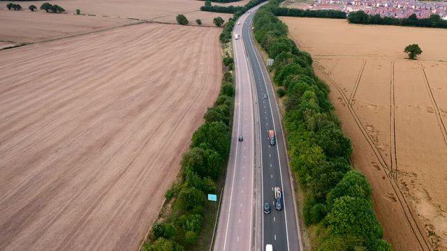 Aerial View over Motorway Across Countryside Fields in UK