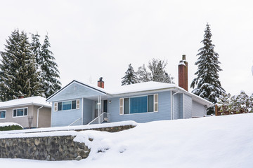 Average North American house in snow on winter cloudy day