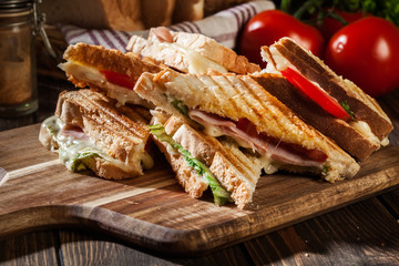 Stack of panini with ham, cheese and lettuce sandwich