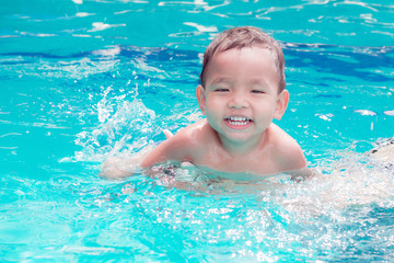Fototapeta na wymiar asian children having fun in a swimming pool at thailand
