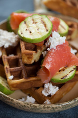 Belgian waffles with trout fillet, grilled zucchini and ricotta cheese, close-up, vertical shot