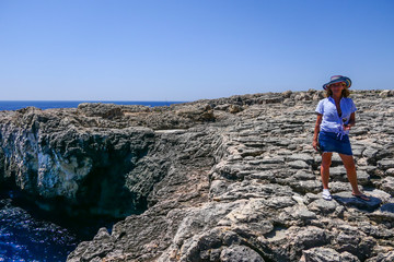 Syracuse, Sicily, Italy A tourist at the  Capo Murro di Porco Lighthouse  at the end of the Maddalena Peninsula on the south eastern tip of Sicily on the Ionian Sea.