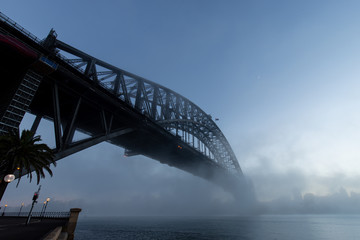 Morning blue hour view of Sydney Harbour Bridge with some fog.