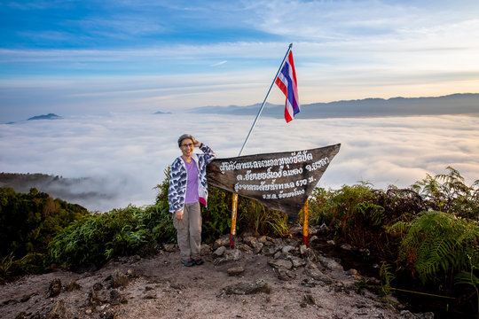 Woman tourist standing at viewpoint of Gunung Silipat. Thai language is name of viewpoint and show metres above sea level MSL.