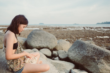 Abstract Young woman in casual style fashion lying on the beach.