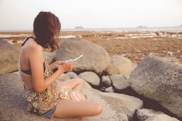 Abstract Young woman in casual style fashion siting on the beach.