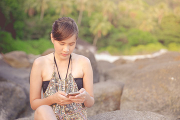 Abstract Young woman in casual style fashion siting on the beach.