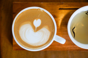 Heart-shaped coffee on a brown wood table