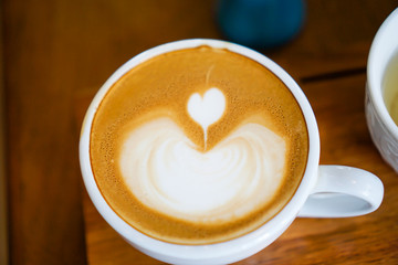 Heart-shaped coffee on a brown wood table