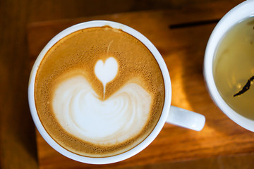 Heart-shaped coffee on a brown wood table