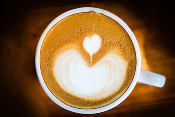 Heart-shaped coffee on a brown wood table