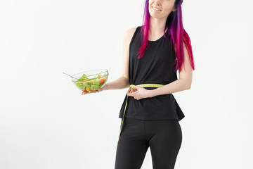 Slim young asian girl with colored hair is measured hanging a measuring tape and holding a light...