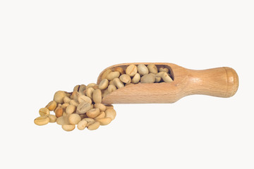 Fresh Raw coffee beans in wood spoon on background.