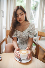 Obraz na płótnie Canvas Asian women relax with hot coffee latte art with empty space .