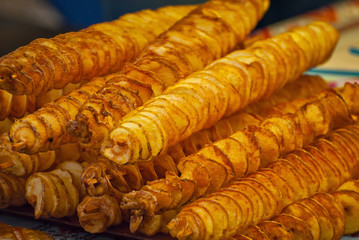Potato chips on a stick. Natural chips are fried and sold at the fair. Fat street food.