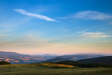 A panorama of a hilly countryside in early morning in the summer
