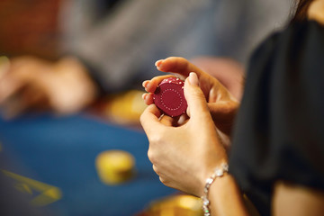 Hands with chips at poker roulette table gambling in a casino.